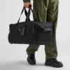 Walizka na kółkach z tkaniny Re-Nylon i skóry Saffiano Walizka na kółkach z tkaniny Re-Nylon i skóry Saffiano